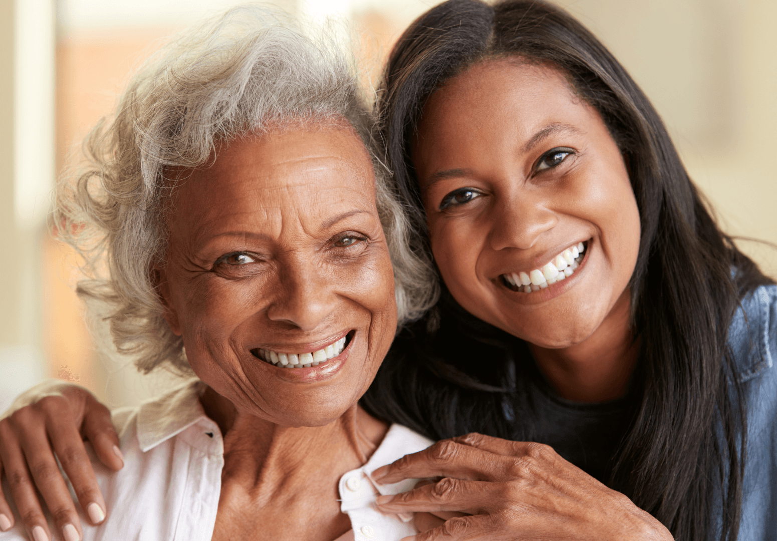 An older woman and her daughter smiling together