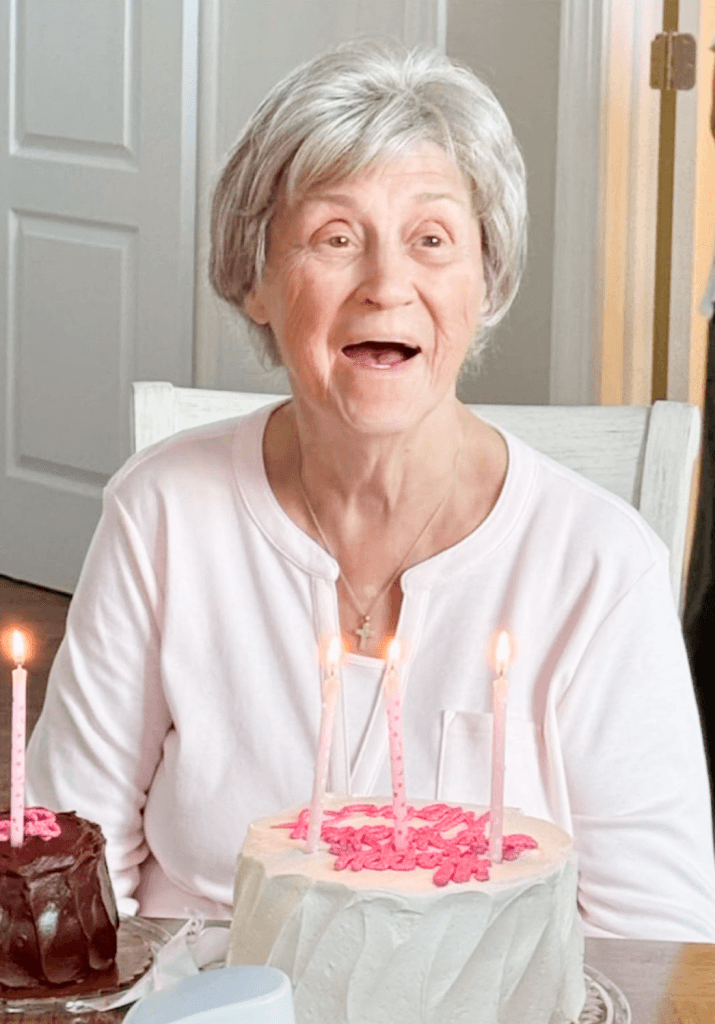 Patricia smiling behind a birthday cake